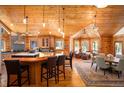 Open-concept living and kitchen area, featuring wood floors and log walls, exudes rustic charm at 11652 Camp Eden Rd, Golden, CO 80403