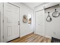 Hallway with a white door, white closet doors, and luxury vinyl plank flooring at 20 1/2 S Sherman St, Denver, CO 80209