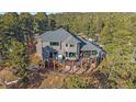 Back of home showing tiered deck, hot tub, outdoor seating and forest views at 4125 Aspen Ln, Evergreen, CO 80439