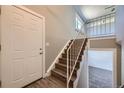 Bright entryway featuring a hardwood staircase, white door, and convenient coat closet at 5771 W 92Nd Ave # 335, Westminster, CO 80031