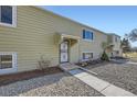 Townhome exterior featuring a tidy gravel yard, concrete walkway, and secure storm door at 5771 W 92Nd Ave # 335, Westminster, CO 80031