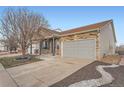 Charming home with stone and siding, landscaped yard, and a spacious driveway leading to an attached garage at 5506 Malta St, Denver, CO 80249