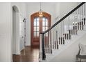 Bright foyer featuring a wood door, a modern chandelier, and stairs with an ornate black and white banister at 3074 Castle Butte Dr, Castle Rock, CO 80109