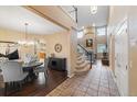 Open concept dining room with hardwood floors, a chandelier, and views into the adjacent living spaces at 6987 Esperanza Dr, Castle Pines, CO 80108