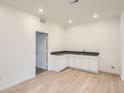 Basement featuring hardwood floors, a sink with countertops, and ample lighting at 7199 Waterleaf Trl, Littleton, CO 80125