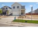 Inviting two-story home with a front porch, complemented by manicured landscaping at 2222 Flower Blossom Ave, Brighton, CO 80601