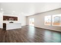 Spacious living area with wood floors, large windows for natural light, and open floor plan at 2222 Flower Blossom Ave, Brighton, CO 80601