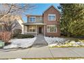 Two-story home with a brick facade and snow-covered walkway at 12454 Knox Ct, Broomfield, CO 80020
