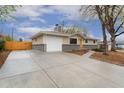 Ranch-style home featuring an attached garage and a concrete driveway at 6448 Ingalls Ct, Arvada, CO 80003