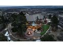 Aerial view of a luxurious estate with a fire pit, meticulously manicured lawns, and mature trees at 7225 Box Canyon Rd, Sedalia, CO 80135