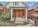 Inviting front porch of a brick home with classic columns and a wooden front door at 3356 Quivas St, Denver, CO 80211