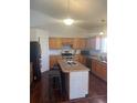 Well-lit kitchen featuring wooden cabinets, stainless steel appliances, and an island with seating at 2170 Granite Dr, Brighton, CO 80603