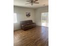Bright living room with hardwood floors, a sliding glass door, and a comfortable brown sofa at 2170 Granite Dr, Brighton, CO 80603
