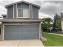 Spacious attached two-car garage providing secure parking and extra storage, complemented by lush green lawn at 2130- 42Nd Ave, Denver, CO 80249