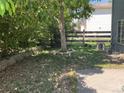 Backyard featuring a small tree, retaining wall, and a wooden fence at 21300 E 42Nd Ave, Denver, CO 80249