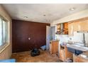 Outdated kitchen with a large window and damage to the walls needing renovation at 415 Winona Ct, Denver, CO 80204
