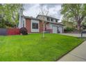 Beautifully landscaped front yard with lush green grass and mature trees at 66 Yank Way, Lakewood, CO 80228