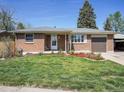 Charming brick home featuring a well-manicured lawn and cozy front porch at 5225 Beech St, Arvada, CO 80002