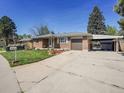 Brick house with a well-maintained lawn, driveway and attached garage with carport at 5225 Beech St, Arvada, CO 80002