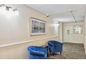 Hallway sitting area with two blue chairs and abstract painting at 3470 S Poplar St # 102, Denver, CO 80224