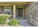 Stone clad home exterior featuring an elegant front door with decorative wreath at 7892 S Country Club Pkwy, Aurora, CO 80016