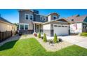 Lovely two-story home with a manicured lawn, stone accents, and an attached two-car garage under a clear sky at 3966 Long Rifle Dr, Castle Rock, CO 80108