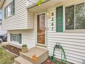 Inviting front entrance showcasing a glass door, green shutters, and a verdant green hose at 8267 High St, Denver, CO 80229
