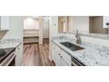 Galley kitchen features stainless steel appliances, granite countertops, and wood flooring at 7483 S Quail Cir # 626, Littleton, CO 80127