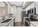 Well lit kitchen featuring stainless steel appliances, white cabinetry, and granite counters at 7483 S Quail Cir # 626, Littleton, CO 80127