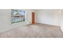 Inviting living room with large windows, neutral carpet, and a classic wooden door at 7172 Kalamath St, Denver, CO 80221