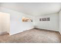 Spacious living room with neutral carpet and natural light at 7172 Kalamath St, Denver, CO 80221