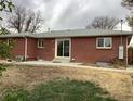 Brick house featuring a patio and sliding glass door leading to a private backyard at 1152 S Eaton St, Lakewood, CO 80232