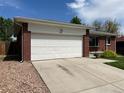 Exterior of a brick home featuring a two-car garage and concrete driveway at 1152 S Eaton St, Lakewood, CO 80232
