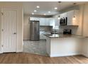Well-lit kitchen featuring white cabinets, stainless steel appliances, and a breakfast bar at 1152 S Eaton St, Lakewood, CO 80232