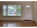 Light-filled living room with hardwood floors, a large window, and a white front door at 1152 S Eaton St, Lakewood, CO 80232