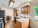 Bright kitchen featuring wooden cabinets, quartz countertops, stainless steel appliances, and access to the dining area at 11707 W 65Th Cir, Arvada, CO 80004