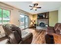 Comfortable living room with a brick fireplace, hardwood floors, and sliding glass doors to the backyard patio at 11707 W 65Th Cir, Arvada, CO 80004