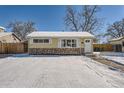 Cute yellow ranch house with snowy yard, freshly painted at 1626 S Wolcott Ct, Denver, CO 80219