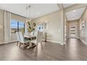 Elegant dining room with hardwood floors, large window, modern light fixture and room for six at 1465 Gentle Rain Dr, Castle Rock, CO 80109
