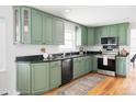 Well-maintained kitchen features stone countertops and stylish green cabinets at 6982 Estes Dr, Arvada, CO 80004