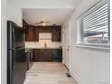 Modern kitchen with dark wood cabinets, stainless steel appliances, and light wood floors at 1533 Xenia St, Denver, CO 80220