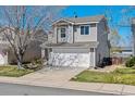 Charming two-story home featuring a two-car garage, driveway and view of the blue sky at 9508 Elk Mountain Cir, Littleton, CO 80125
