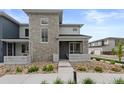 Beautiful gray two-story home featuring stone accents, well-maintained landscaping, and a welcoming front porch at 16421 Askins Loop, Parker, CO 80134