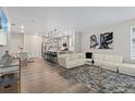 Open-concept living room and kitchen with modern lighting, hardwood floors, and stylish decor at 16421 Askins Loop, Parker, CO 80134