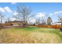 Large, fenced backyard featuring a lush lawn and mature trees at 7604 S Lamar Ct, Littleton, CO 80128