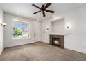 Inviting living room with fireplace, ceiling fan, and natural light, creating a cozy atmosphere at 5572 Killarney St, Denver, CO 80249