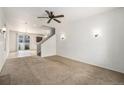 Bright living room with carpet, ceiling fan, and staircase leading to the second floor at 5572 Killarney St, Denver, CO 80249