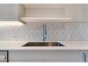 Close up of modern stainless steel sink and faucet with a geometric backsplash design at 2876 W 53Rd Ave # 122, Denver, CO 80221