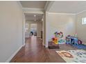 Inviting hallway with hardwood floors, crown molding, and views into other rooms at 14997 Elsinore Ave, Parker, CO 80134