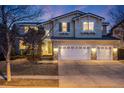 Inviting two-story home features stone accents, a three-car garage and a covered porch at 683 Ridgemont Cir, Highlands Ranch, CO 80126